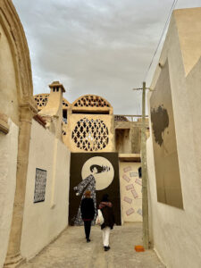 Tunisian women walking down a street Djerbahood dedicated to the extreme emigration in the country.