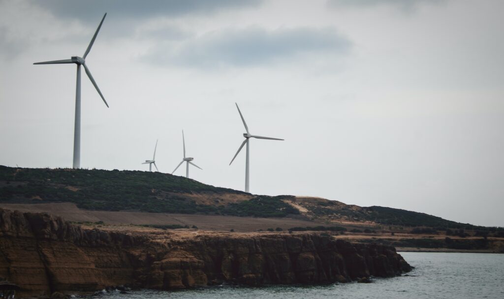 Breathtaking winter view of the picturesque coastline in Hawaria, Tunisia, showcasing four majestic windmills standing against the lush green hills.