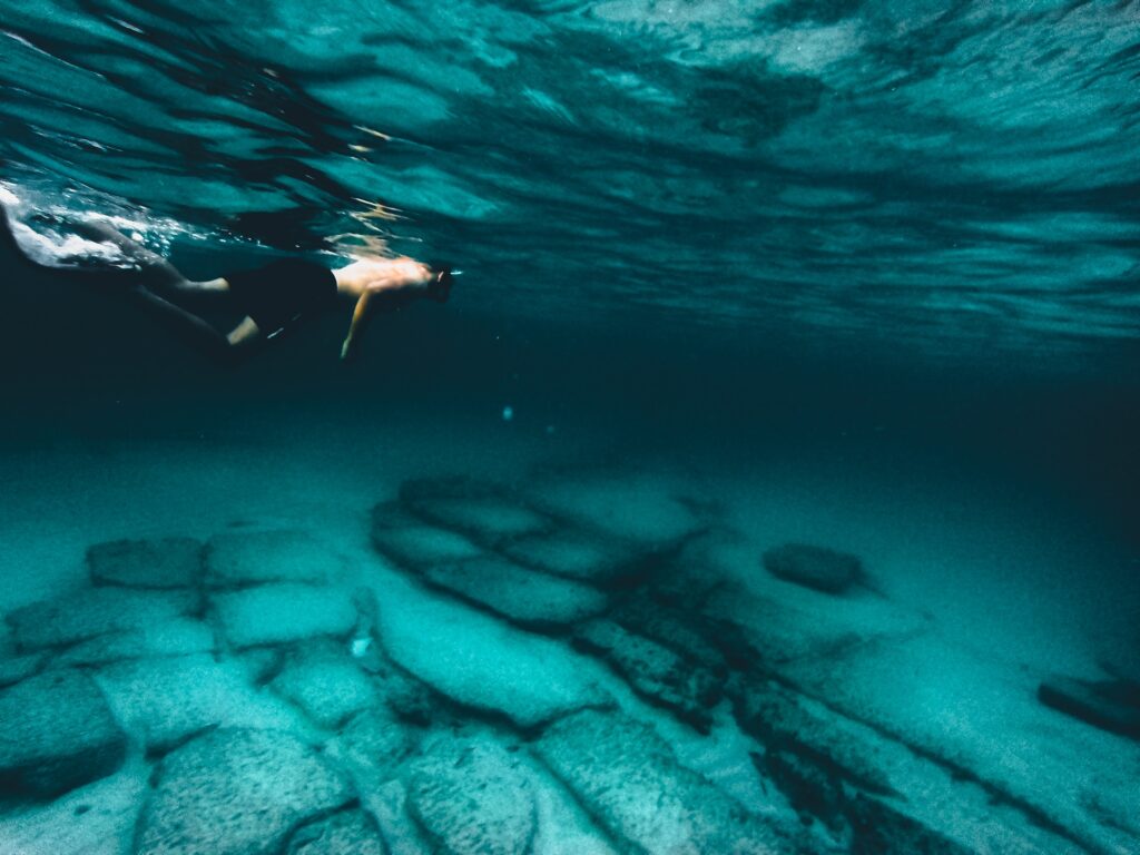 Breathtaking photo of a snorkeler exploring the crystal-clear, turquoise blue waters of Mahdia, Tunisia.