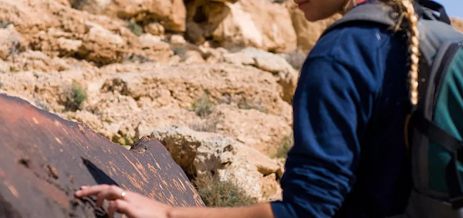 negev desert tourism, a tourist touches a sacred rock solimar international