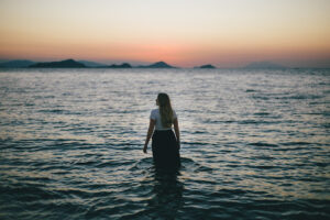 The image of this woman in the ocean represents the powerlessness many family members of migrants feel.